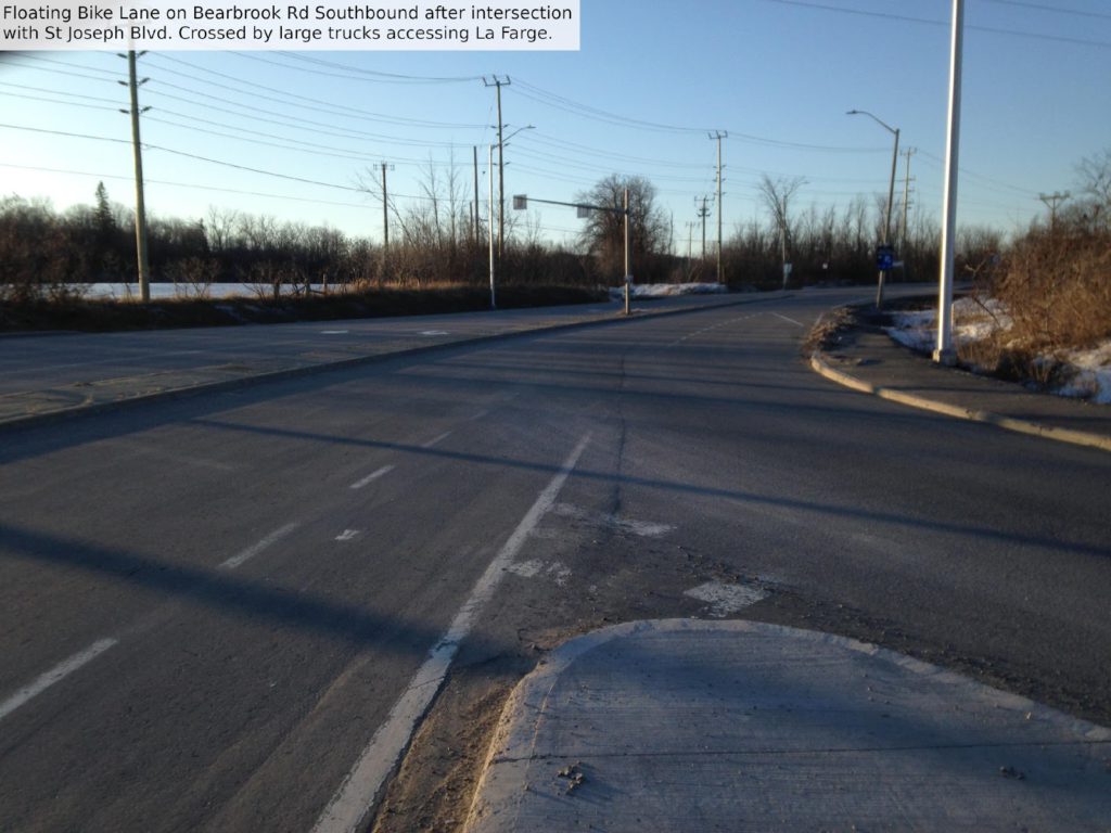 Floating bike lane on Bearbrook Rd southbound after intersection with St Joseph Blvd. Crossed by large trucks accessing LaFarge.