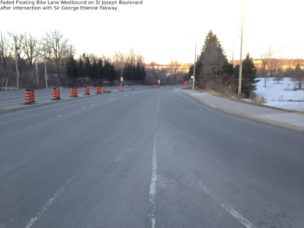 Faded floating bike lane westbound on St Joseph Boulevard after intersection with Sir George-Etienne Cartier Parkway.