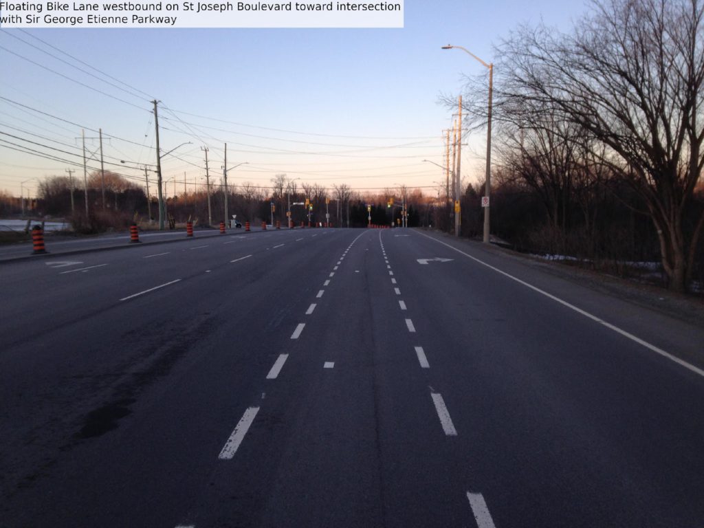Floating bike lane westbound on St Joseph Boulevard toward intersection with Sir George-Etienne Cartier Parkway.