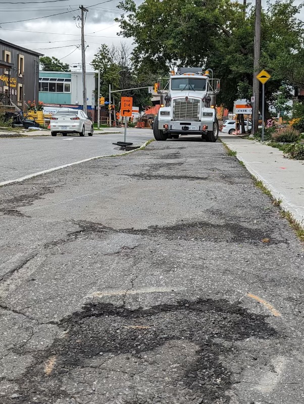 Image of a constraction truck parked on a cycle track in a state of disrepair