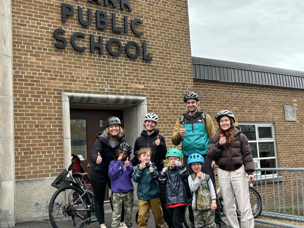 Bike bus group with their thumbs up. Some kids are still eating their donuts.