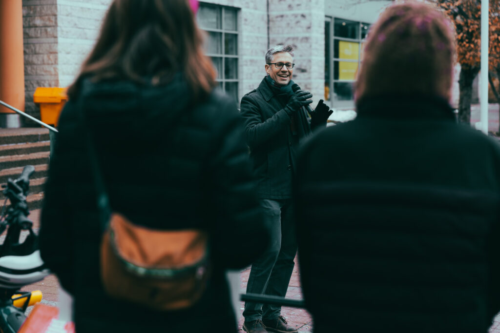 William van Geest, executive director of Ecology Ottawa, addressing the Bill 60 rally. Two people can be seen in the foreground listening to him.