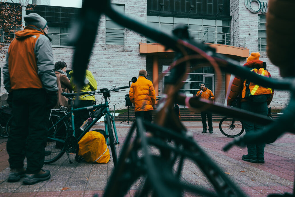 Crowd listening to a speaker at the Bill 60 rally. There’s a blurry bike in the foreground.