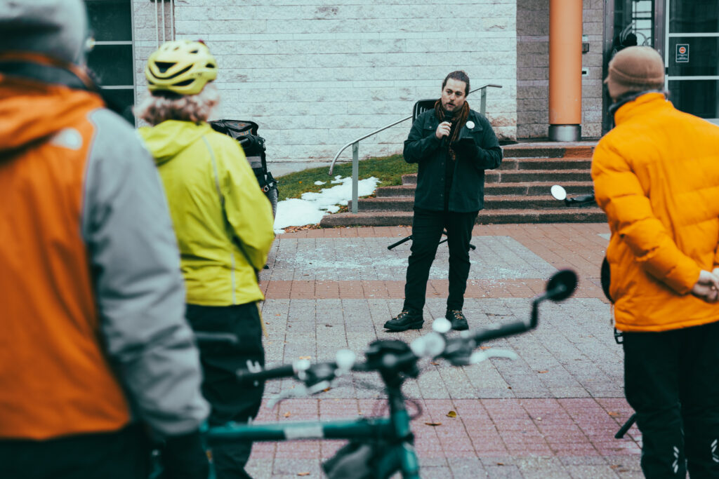 Etienne Lefebvre from Strong Towns Ottawa addressing the Bill 60 rally. People listening to him in the foreground.