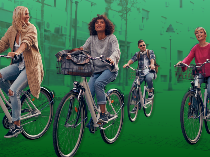 Four people riding their bike share rental together over a green city background